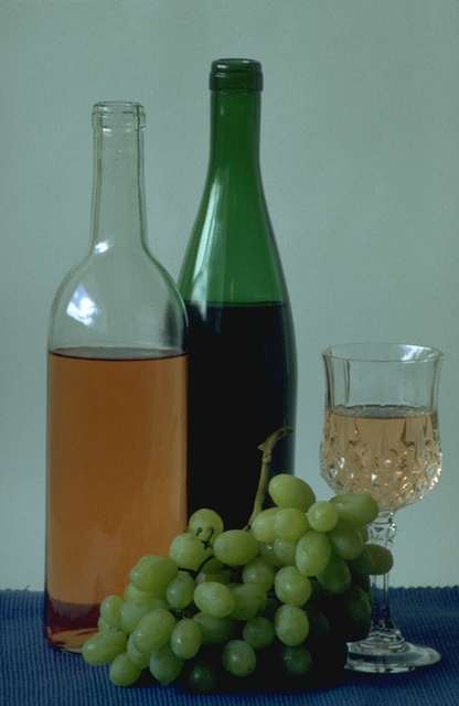 Botellas de vino blanco y tinto, copa y uva
